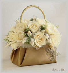 a bouquet of white flowers in a gold purse