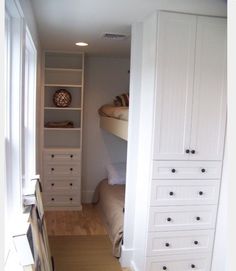 there is a bunk bed in the corner of this room with built - in shelves