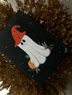 a graduation cap with a ghost on it and stars around the neck is hanging from a tree