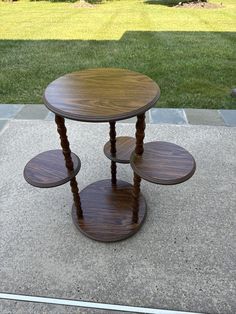 three tiered wooden table sitting on top of a sidewalk