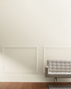 a white couch sitting in front of a wall