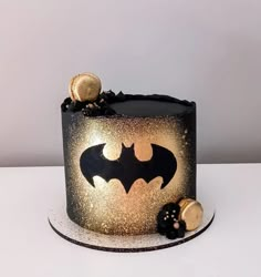 a black and gold batman cake on a white table