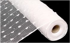 a roll of white mesh sitting on top of a black surface