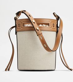 Characterized by a shaped trim inspired by the iconic chain accessory, this bucket bag comes with an adjustable handle with branded rivets. Crafted in calfskin leather and linen blend canvas, it comes with the maxi Tod's logo stamped on the bottom. Closed with a practical drawstring, it complements your summer outfit with the elegance of natural shades and essential lines. Bucket Bag Style, Leather And Canvas, Orange Bag, Denim Bag, Brown Beige, Leather Items, Rivets, Calf Leather, Fashion Bags