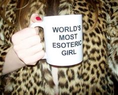 a woman holding a coffee mug with the words world's most esoteric girl on it