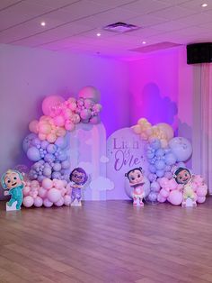 there are many balloons on the floor in front of this stage set up for a birthday party