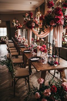 a long table with flowers and candles on it is set for a wedding reception at the end of an aisle