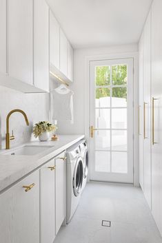 a washer and dryer in a white laundry room next to a doorway with glass doors