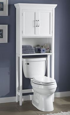 a white toilet sitting in a bathroom next to a cabinet with towels on top of it