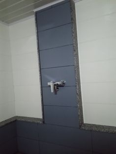 an open door in a bathroom with gray and white walls