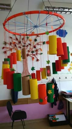 a room filled with lots of different colored paper decorations hanging from the ceiling above a table