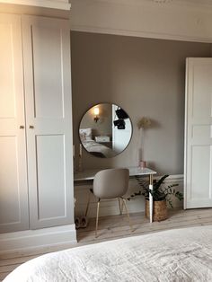 a bedroom with a bed, dresser and mirror in it's corner next to a closet