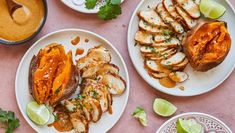 two plates with grilled chicken and sweet potato wedges next to some dipping sauce