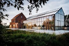 a large glass building sitting on top of a lush green field