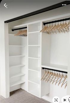 an empty closet with white shelves and wooden clothes hangers on the wall next to it