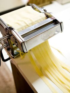 a pasta machine is being used to make spaghetti