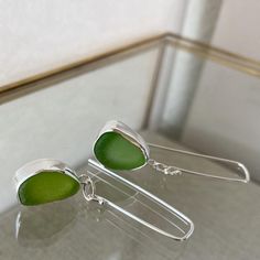 A delicate yet bold statement. Each pair of earrings is handmade so you'll appreciate every subtle intricacy. Can be worn while taking a casual stroll on the beach combing for sea glass. Or, paired with your favorite evening wear to complement those amazing shoes you just bought.For a made to order you would choose your sea glass or supply me with your own sea glass that will be made into a *similar* set of earrings. Please message me with any questions!They arrive in sage jewel box with ribbon. Sea Glass Jewellery Ideas, Sea Glass Silver Jewellery, Sea Glass Jewellery, Earrings Piece, Fish Jewelry Silver, Sea Glass Jewelry Earrings, October Jewelry, Seaglass Jewelry, Fish Jewelry