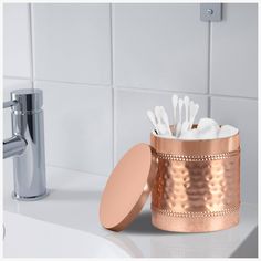 a bathroom sink with a toothbrush holder and soap dispenser