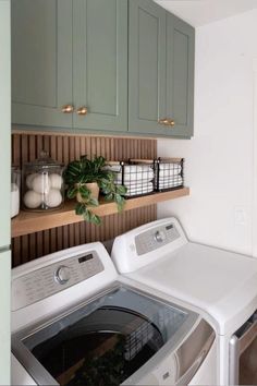 a washer and dryer in a small room with green cabinets on the wall