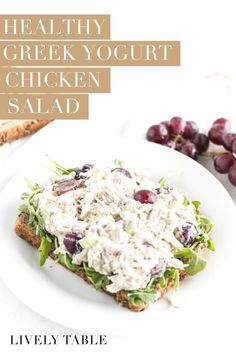 healthy greek yogurt chicken salad on a white plate with bread and grapes in the background