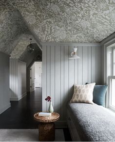 a room that has some kind of wall paper on the walls and a bench in front of it