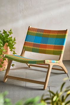 a wooden chair sitting next to a potted plant