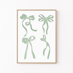 a green bow and ribbon print on a white wall next to a wooden framed frame