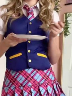 a girl in a school uniform is holding a plate