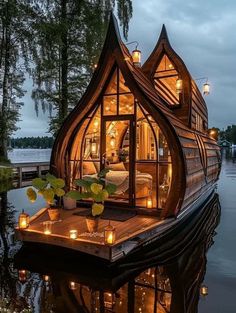 a boat house with candles on the deck and lights in the windows that are lit up