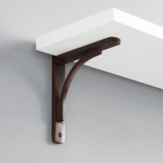 a close up of a wall mounted shelf with a metal hook on the top and bottom