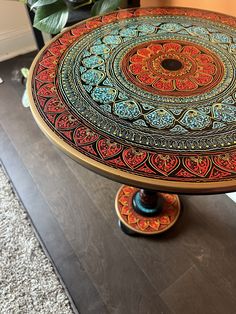 an ornately decorated cake plate sitting on top of a wooden table next to a potted plant