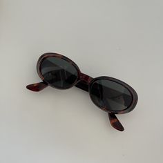 These round oval sunglasses are your everyday classic frames.  Featuring a brown tortoise frame with black lens.  This style is unisex.  True genuine vintage sunglasses from the 90s.   - 400 uv  - new vintage from the 90s Measurements:  Lens Height: 32mm  Lens Width: 50mm  Bridge:  17mm  Arm temple: 140mm Frame width: 133mm Also available in black  Frame material: polyurethane  Lens material: glass Includes sunglasses pouch Glasses Inspiration, Sunglasses Pouch, Tortoise Shell Sunglasses, Stylish Glasses, Brown Sunglasses, Funky Jewelry, Oval Sunglasses, Vintage Sunglasses, Sunglasses Vintage