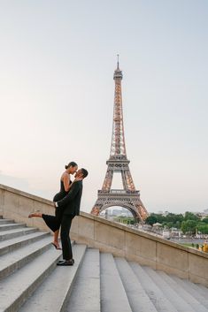 a man and woman in front of the eiffel tower