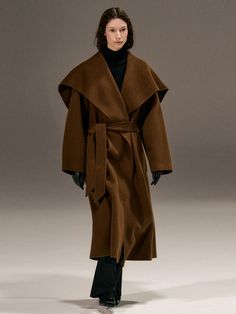 This luxurious 100% wool coat combines timeless elegance with practical warmth, featuring a versatile shawl collar and detachable belt for multiple styling options. The relaxed silhouette offers a comfortable, blanket-like drape that wraps effortlessly around the body, while the handcrafted construction ensures exceptional quality. Available in both brown and black, this classic piece includes convenient side welt pockets, a full twill lining, and a back center vent for ease of movement.Color: b Bronze Autumn, Embellished Coat, Flamboyant Natural, Vacation Fashion, Thick Wool, Wrap Coat, Winter Vacation, W Concept, Iconic Photos