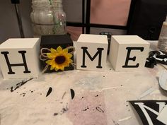 three blocks with the letters home and a sunflower