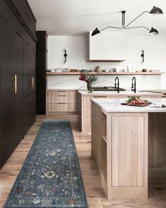 a kitchen with an area rug in front of the sink and countertop, along with wooden cabinets