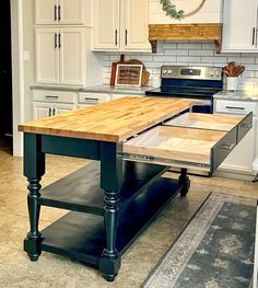 a kitchen with an island in the middle and white cabinets on both sides is shown