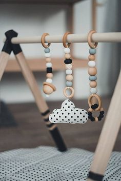 a baby crib with a wooden mobile hanging from it's side