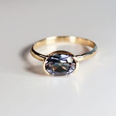 This beautiful oval lab grown color change sapphire ring was made of 8mmx6mm oval sapphire stone in 14k gold half bezel bezel setting and 14k yellow gold 2mm hammered band. It's perfect as a solitaire engagement ring or statement ring. DETAILS Ring Band: 14K YELLOW GOLDRing Band size: 2mm wide x 1mm thick half roundRing Band is hammered or smooth by requested.Gemstone: Lab grown color change sapphireGemstone size and cut: 6x8mm oval cutCarat weight : 1.25 ct. weightGemstone Quality : AAA *** All East West Half Bezel, Half Bezel Ring, Redlands California, Color Change Sapphire, Oval Sapphire Ring, Half Bezel, Bezel Engagement Ring, Small Workshop, Hammered Band