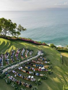 an aerial view of a wedding ceremony with the ocean in the background