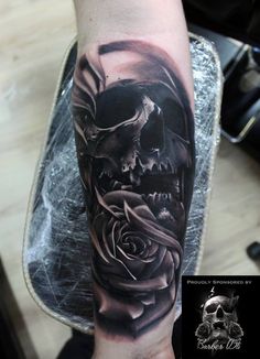 a man's arm with a skull and rose tattoo on it