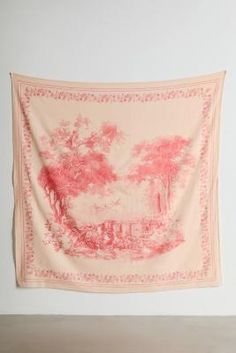 a pink and white tapestry hanging on a wall