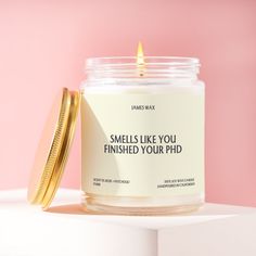 a candle that is sitting on top of a white shelf next to a pink wall