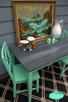 a table with two chairs and a painting on the wall