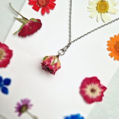 This Pink Rose necklace is a beautiful and unique piece of jewellery that features a real pink rose covered in resin. As a symbol of femininity, grace, and fresh love, this necklace is the perfect gift for a loved one on special occasions like Birthdays and Valentine's Day. The dried flower pendant is around 2 cm in size and hangs from a stylish silver chain that measures approximately 21 cm in length. Please note that as each piece is unique, the size may vary slightly due to natural variations Rose Flower Charm Necklace For Mother's Day, Rose Necklace With Flower Charm For Mother's Day, Delicate Rose Necklaces For Valentine's Day, Dainty Rose Colored Necklace For Her, Dainty Rose Necklace For Her, Dainty Rose Necklace As Gift For Her, Delicate Rose Necklace With Roses Detail, Dainty Rose Necklace With Delicate Chain, Rose Flower Pendant Necklace For Mother's Day