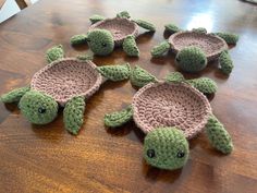 four crocheted sea turtles sitting on top of a wooden table