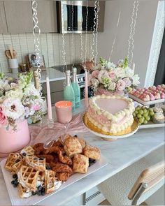 a table topped with cakes and waffles covered in frosting next to flowers