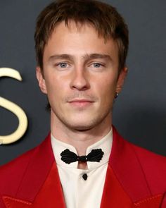 a man wearing a red suit and bow tie