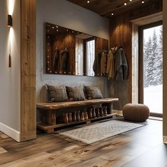 a wooden bench sitting in front of a window next to a wall mounted coat rack