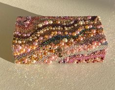 a multicolored beaded purse sitting on top of a white table next to a wall